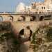 Il viottolo a un certo punto va in salita e ci porta in un punto in cui, girandoci, possiamo avere una visione dinsieme dei due ponti con alle spalle le case del centro storico di Polignano a picco sul mare